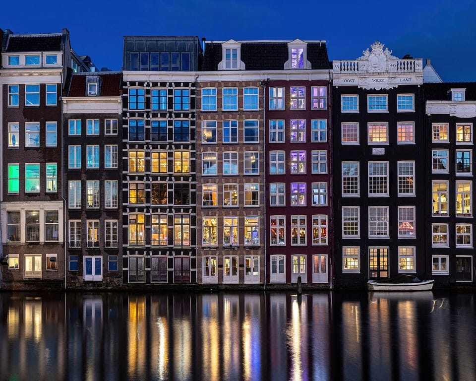 Canal houses reflected in the water at dusk